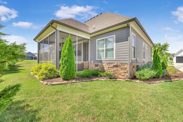 view of side of home with a sunroom and a yard