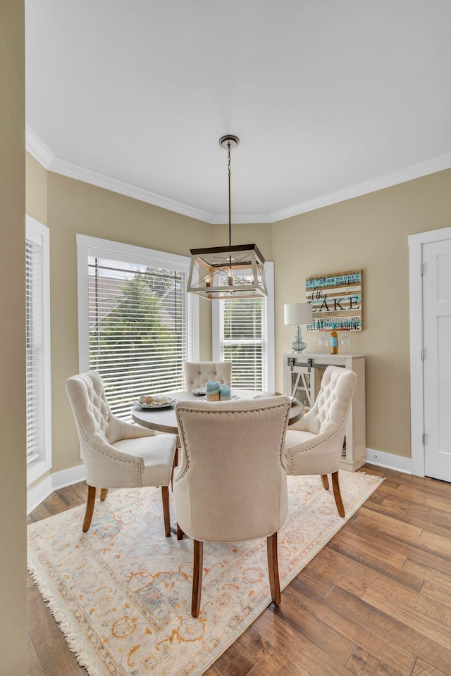 dining space with crown molding and hardwood / wood-style floors