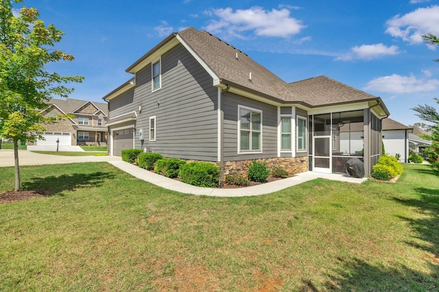 back of house with a garage, a sunroom, and a yard