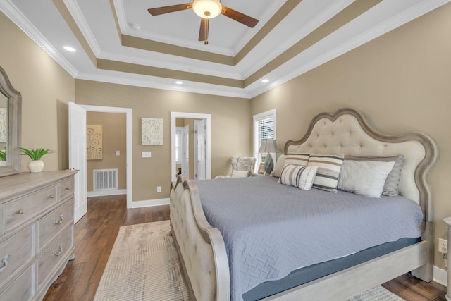 bedroom with a raised ceiling, ornamental molding, and dark hardwood / wood-style flooring