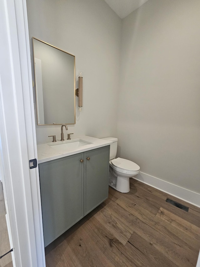 bathroom featuring vanity, hardwood / wood-style floors, and toilet