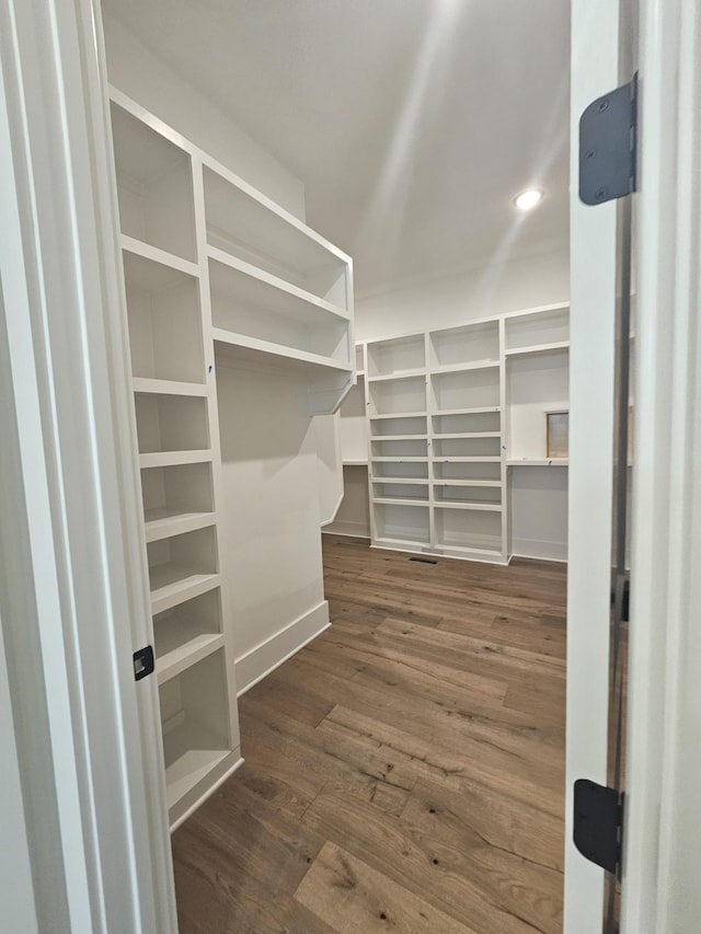 walk in closet with dark hardwood / wood-style floors