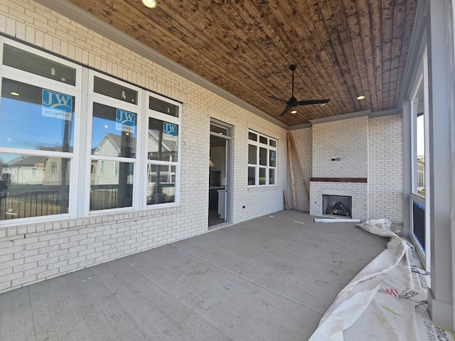 view of patio / terrace with an outdoor brick fireplace and ceiling fan