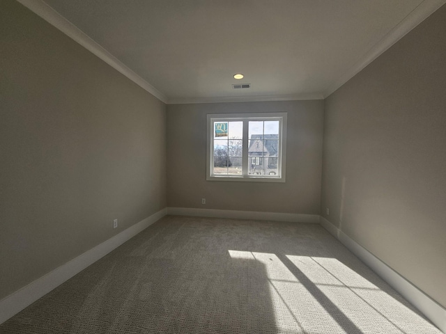 empty room featuring crown molding and light carpet