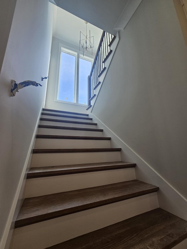 stairway featuring an inviting chandelier