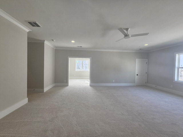 spare room featuring ornamental molding, light carpet, and ceiling fan