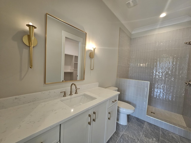 bathroom with vanity, toilet, and tiled shower