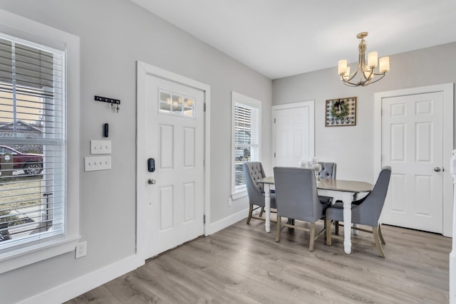 dining area with a notable chandelier and light hardwood / wood-style flooring