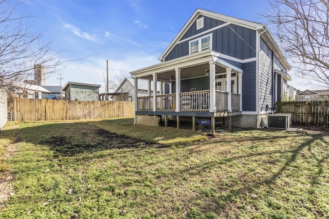 rear view of house with central AC, a lawn, and ceiling fan