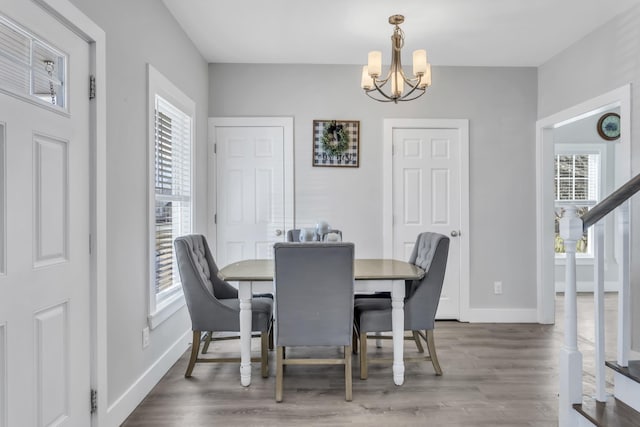 dining area with hardwood / wood-style flooring and a notable chandelier