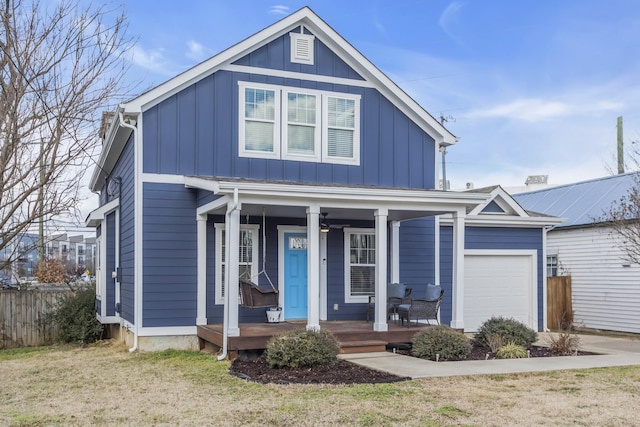 view of front of home with a garage, covered porch, and a front yard