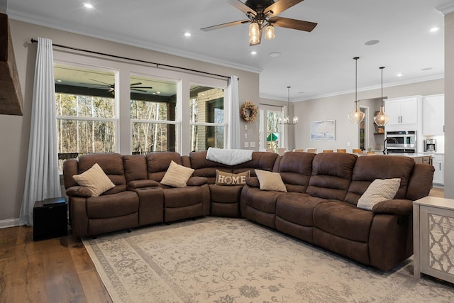 living room featuring crown molding, ceiling fan with notable chandelier, and light wood-type flooring