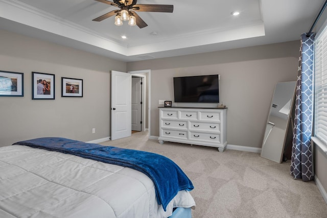 carpeted bedroom featuring ceiling fan and a raised ceiling