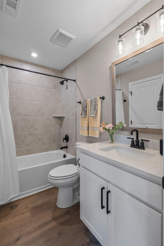 full bathroom featuring shower / bathtub combination with curtain, hardwood / wood-style floors, vanity, and toilet