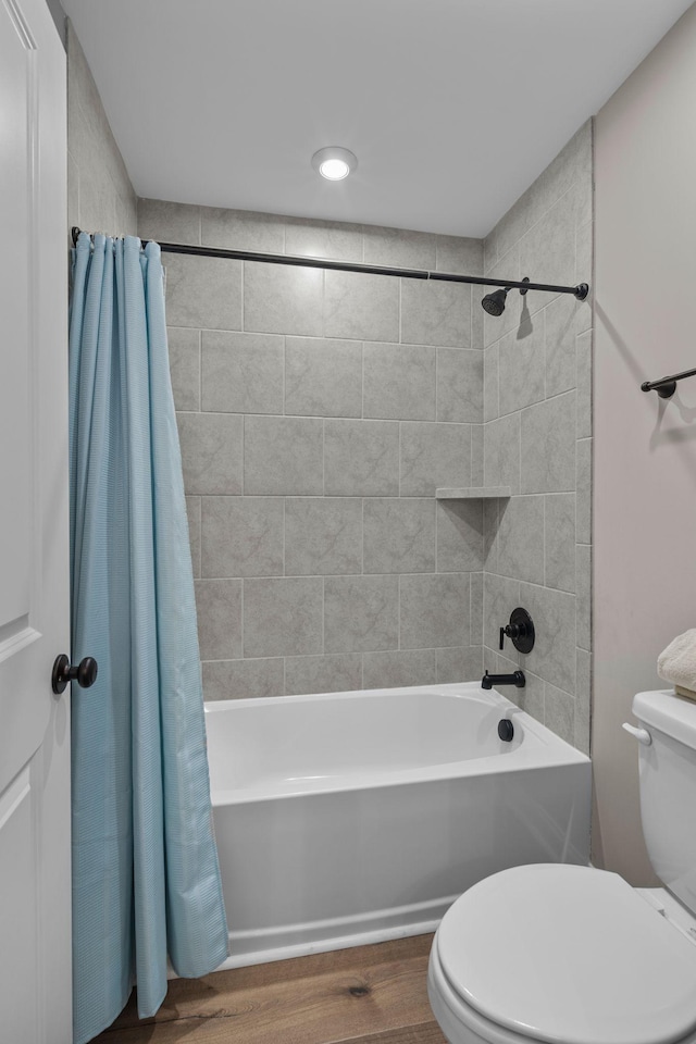 bathroom with shower / tub combo with curtain, hardwood / wood-style floors, and toilet