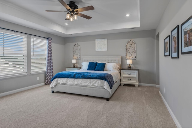 bedroom featuring a raised ceiling, ceiling fan, and carpet