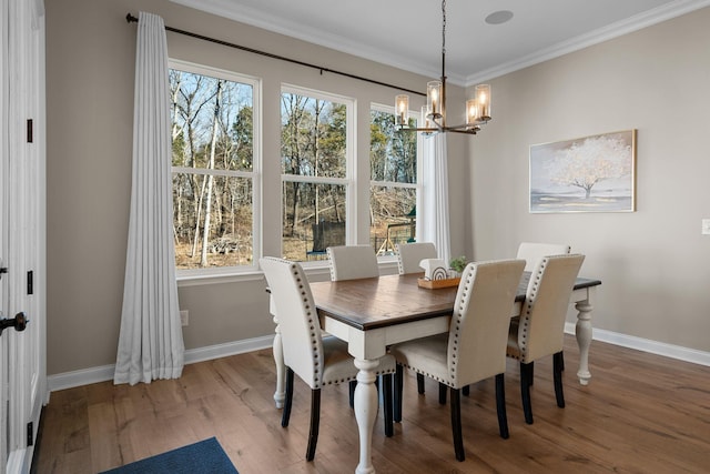 dining space with wood-type flooring, a chandelier, and crown molding