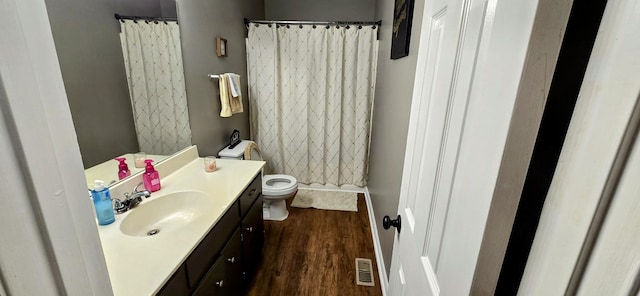 full bathroom featuring toilet, a shower with shower curtain, wood finished floors, vanity, and visible vents