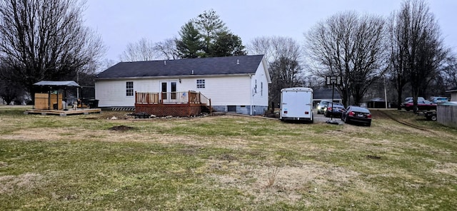 rear view of property featuring a deck and a lawn