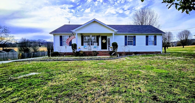 ranch-style house with covered porch, fence, and a front lawn