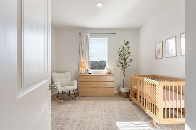 carpeted bedroom featuring a nursery area