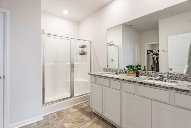 bathroom featuring vanity and a shower with shower door