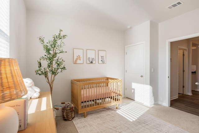 bedroom featuring a crib and carpet flooring