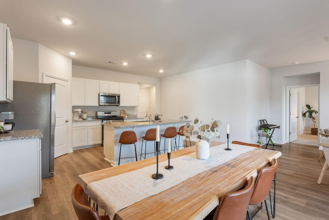 dining space with sink and light hardwood / wood-style flooring