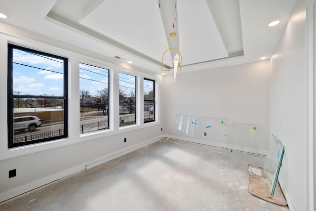 empty room featuring concrete flooring and a raised ceiling