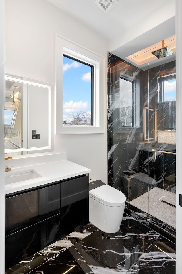 bathroom featuring vanity, toilet, and tiled shower