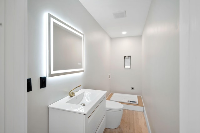 bathroom with vanity, hardwood / wood-style floors, and toilet