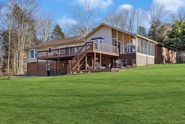 back of property with a yard, a sunroom, and a deck