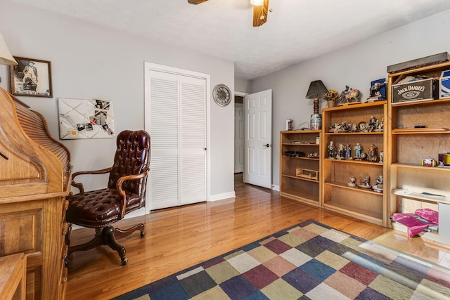 home office featuring wood-type flooring and ceiling fan