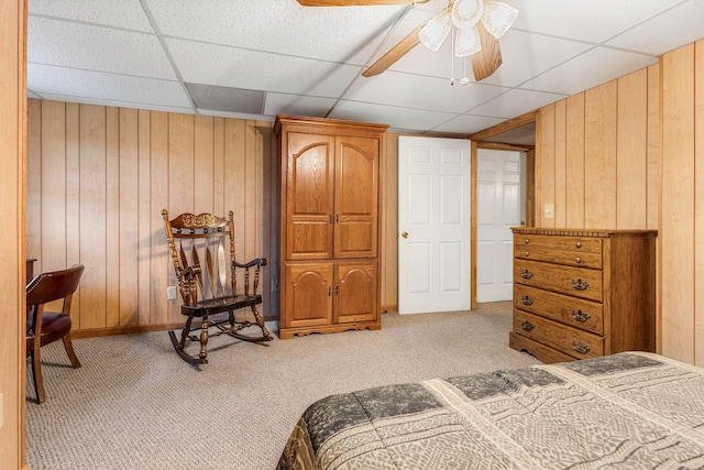 bedroom featuring light colored carpet and wooden walls