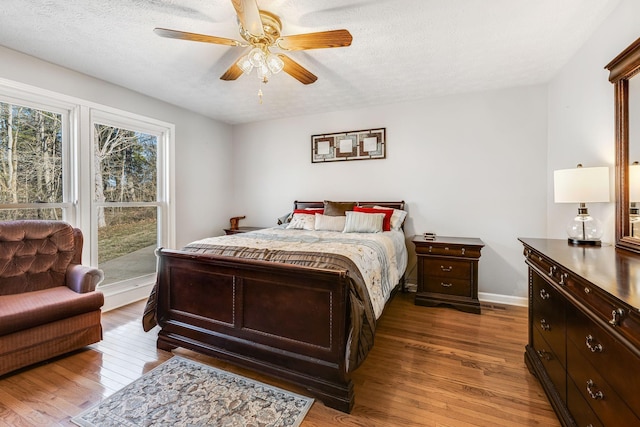 bedroom with hardwood / wood-style flooring, ceiling fan, and a textured ceiling