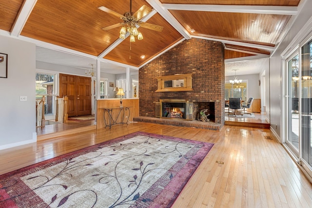 living room with a brick fireplace, light hardwood / wood-style flooring, and a healthy amount of sunlight