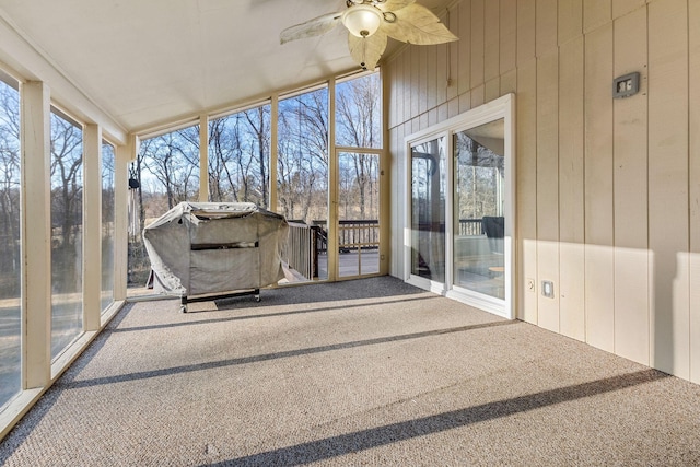 unfurnished sunroom featuring ceiling fan