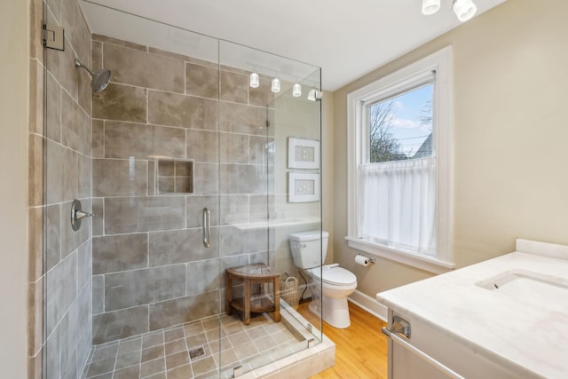 bathroom with vanity, toilet, a shower with door, and wood-type flooring