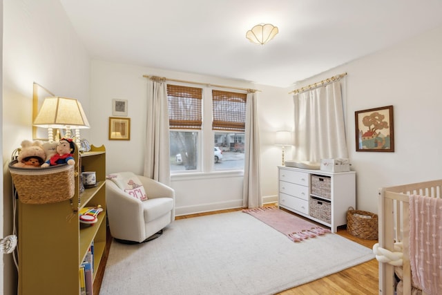 bedroom featuring hardwood / wood-style flooring and a nursery area