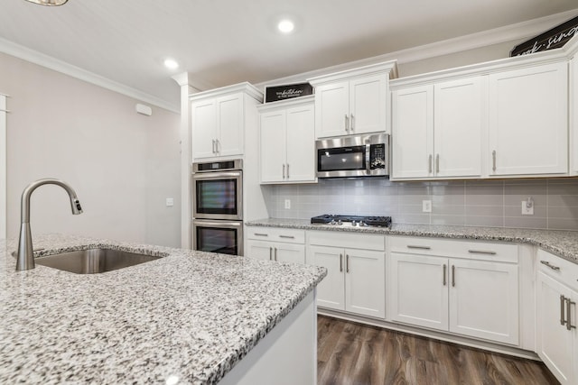 kitchen featuring white cabinetry, appliances with stainless steel finishes, sink, and crown molding