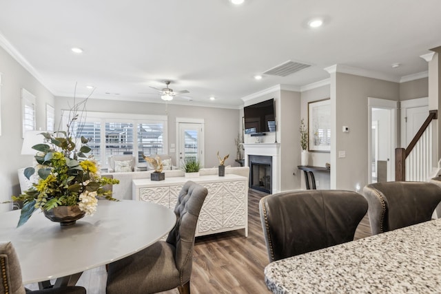 dining space featuring hardwood / wood-style flooring, ornamental molding, and ceiling fan