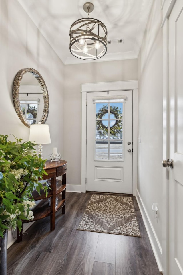 foyer entrance with crown molding and dark hardwood / wood-style floors