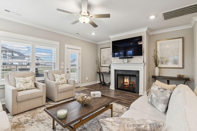 living room featuring hardwood / wood-style flooring, ornamental molding, and ceiling fan