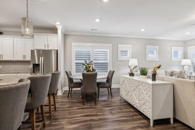 kitchen featuring dark hardwood / wood-style floors, white cabinets, stainless steel fridge, hanging light fixtures, and ornamental molding