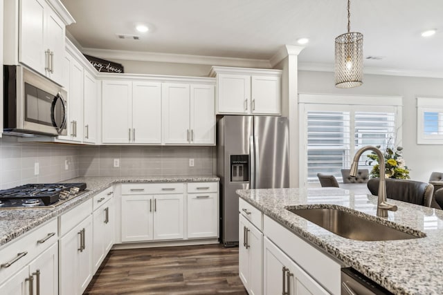 kitchen featuring sink, white cabinetry, crown molding, decorative light fixtures, and stainless steel appliances