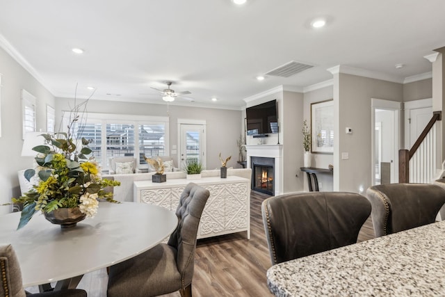 dining area featuring hardwood / wood-style floors, a wealth of natural light, ornamental molding, and ceiling fan