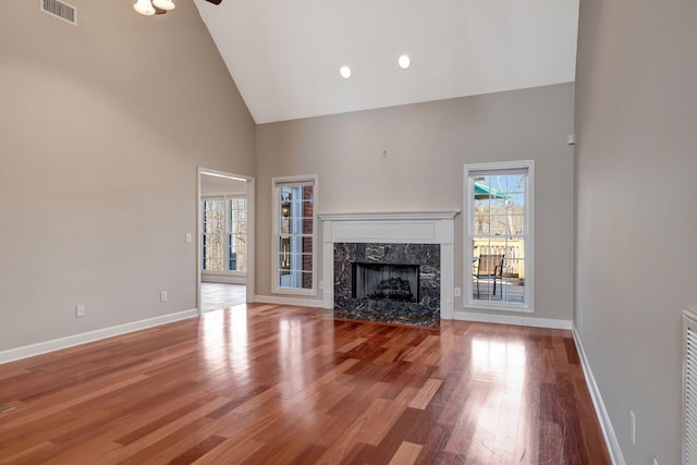 unfurnished living room with hardwood / wood-style flooring, ceiling fan, high vaulted ceiling, and a fireplace