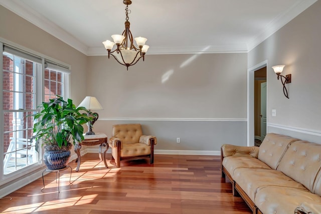 living area featuring crown molding, a chandelier, and hardwood / wood-style floors