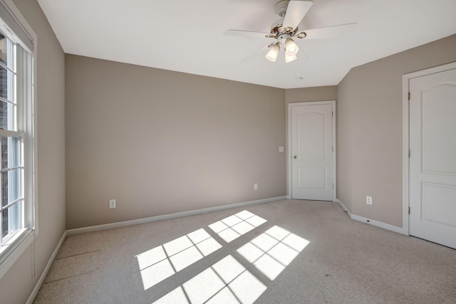 spare room with ceiling fan and light colored carpet