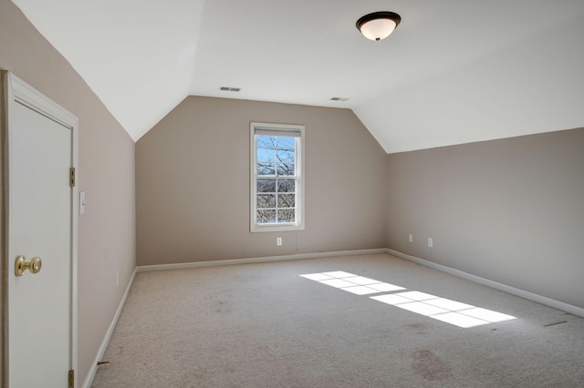 bonus room with vaulted ceiling and light colored carpet